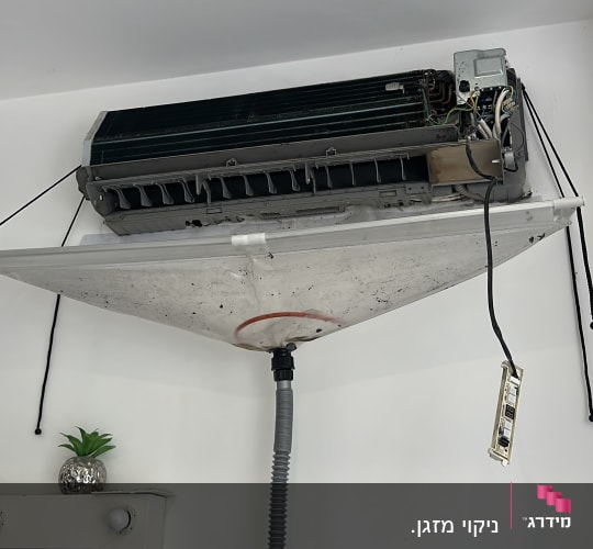 מזגן מפורק עם כיסוי ניקוז תלוי על הקיר